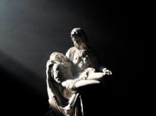 man in white and black jacket and pants sitting on black surface