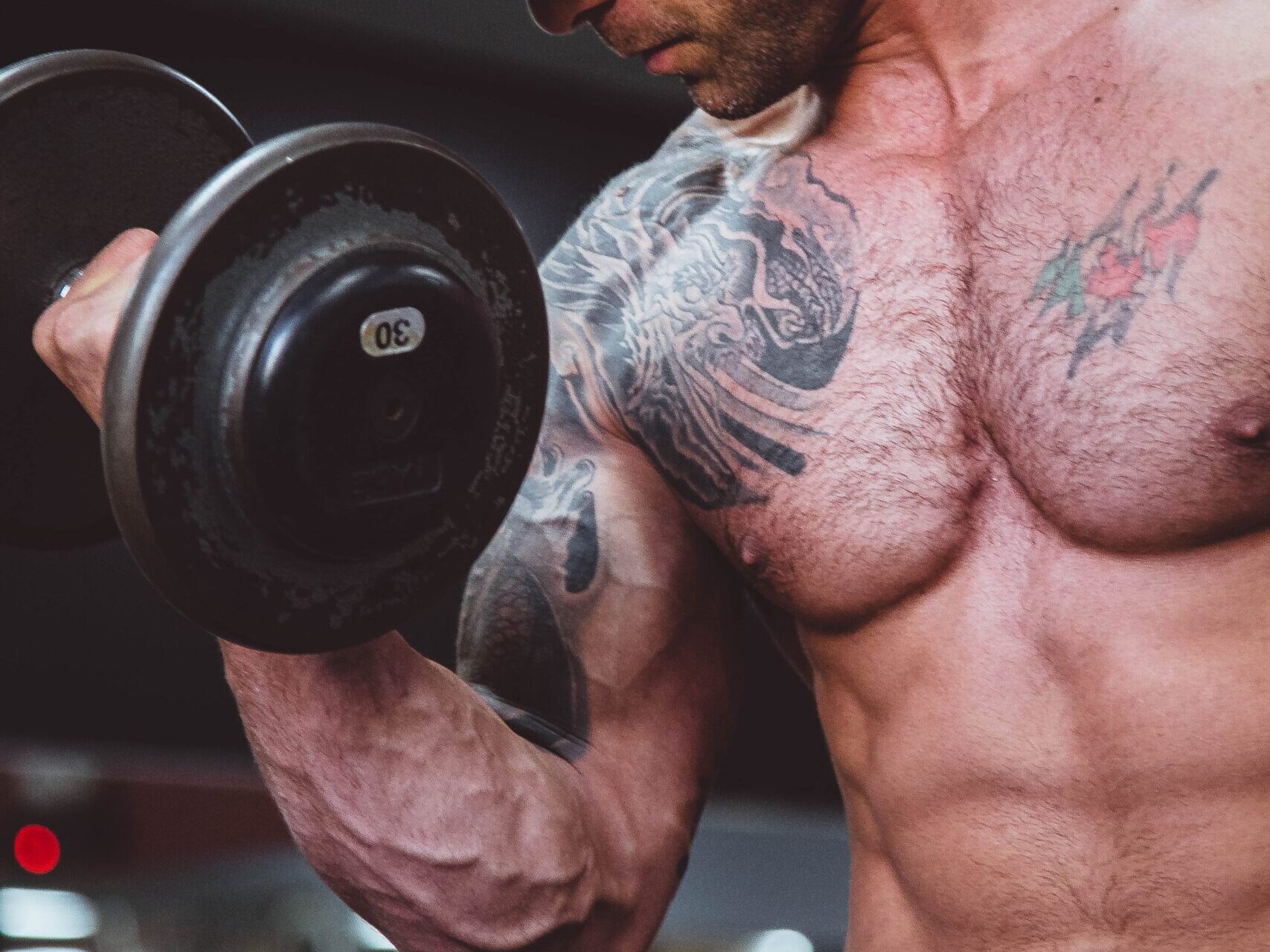 topless man holding black dumbell on right hand