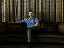 man in blue shirt sitting on couch
