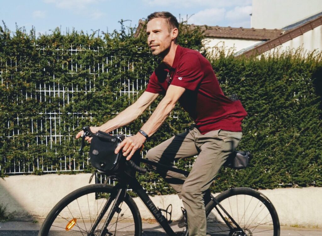 man in red polo shirt riding on black bicycle