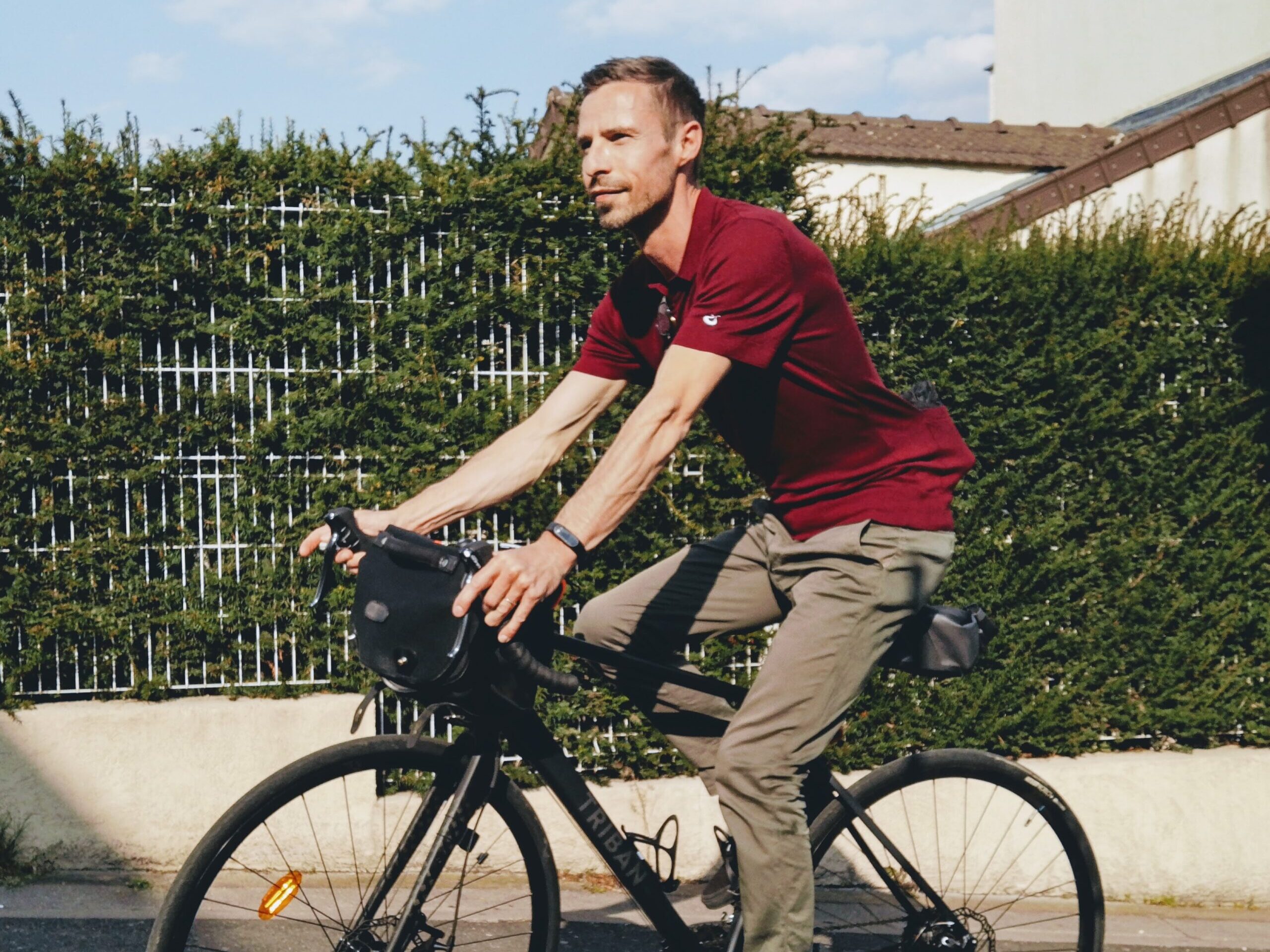 man in red polo shirt riding on black bicycle