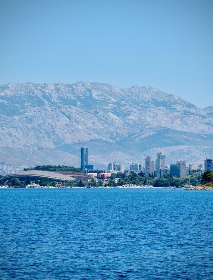 body of water near mountain during daytime