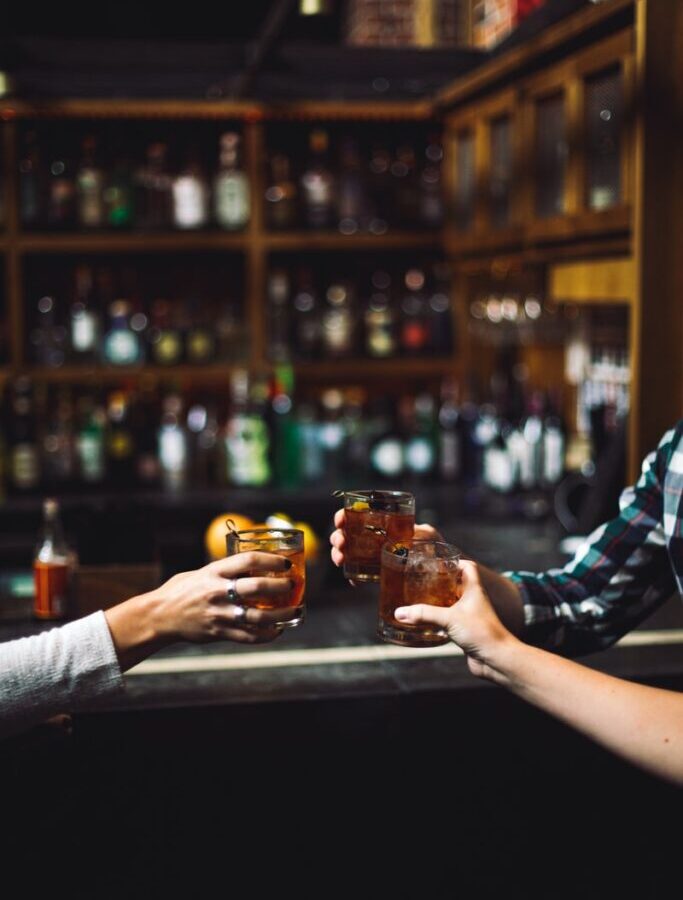 three person holding clear drinking glasses