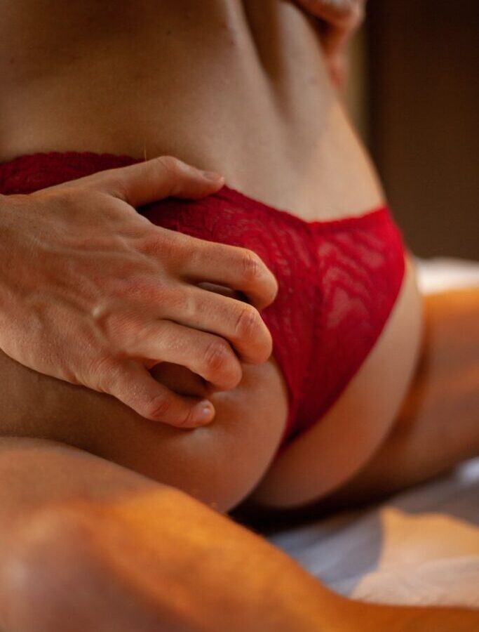 person in red panty lying on bed