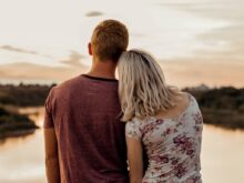 man and woman standing on brown field during daytime