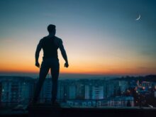 silhouette photography standing on peak front of high-rise buildings