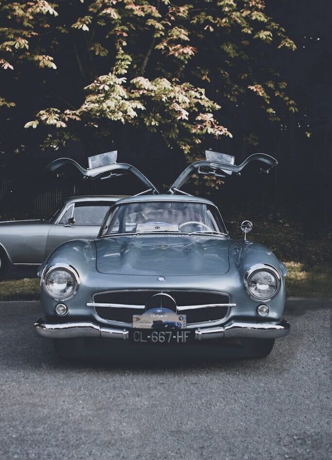 a car parked in a parking lot next to a tree